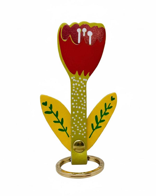 Tulip Schlüsselanhänger Acid Green: Dekorativer Tulpen-Schlüsselanhänger mit rotem Blütenblatt, grün-gepunktetem Stiel und gelben Blättern, befestigt an einem goldfarbenen Ring. Hergestellt aus echtem Leder.
