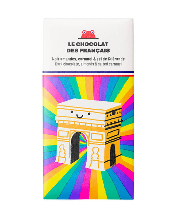 Triomphe Dunkle Schokolade mit Mandeln und gesalzenem Karamell 70g, verpackt in einer verspielten Hülle mit lächelndem Arc de Triomphe vor regenbogenfarbenen Strahlen.