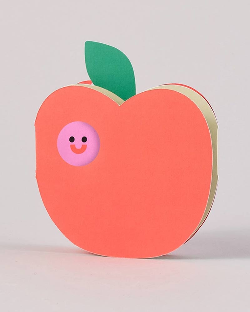 Stapel pfirsichförmiger Papierblätter mit grünem Papierblatt und lächelndem Gesicht auf der Vorderseite, passend zur Apple & Worm Karte zum Ausklappen von Human Empire Shop.