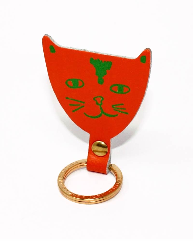 Cat Schlüsselanhänger Orangerot aus echtem Leder, geformt wie ein Katzenkopf mit grünem Gesichtsdruck, befestigt an einem vergoldeten Ring von Ark Colour Design.