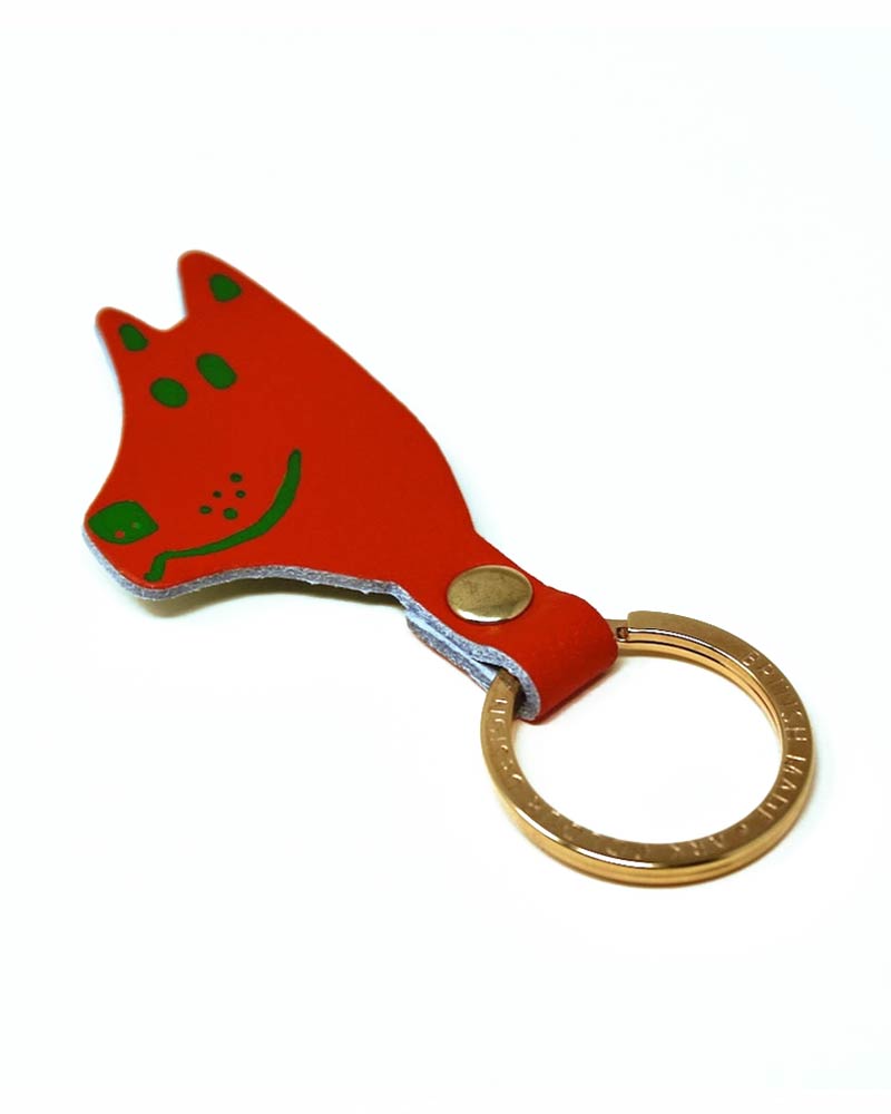Kleiner roter Leder-Schlüsselanhänger Dog von Ark Colour Design, in Form eines Fuchskopfes mit grünen Details, an vergoldetem Ring befestigt.