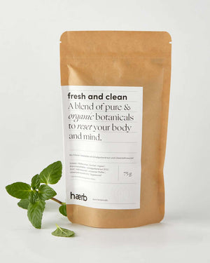 Haerb Bio Teemischung Fresh & Clean in 75g Kraftpapierbeutel, enthält Pfefferminze, Schafgarbenkraut und Löwenzahnwurzel, mit frischen Minzblättern daneben.