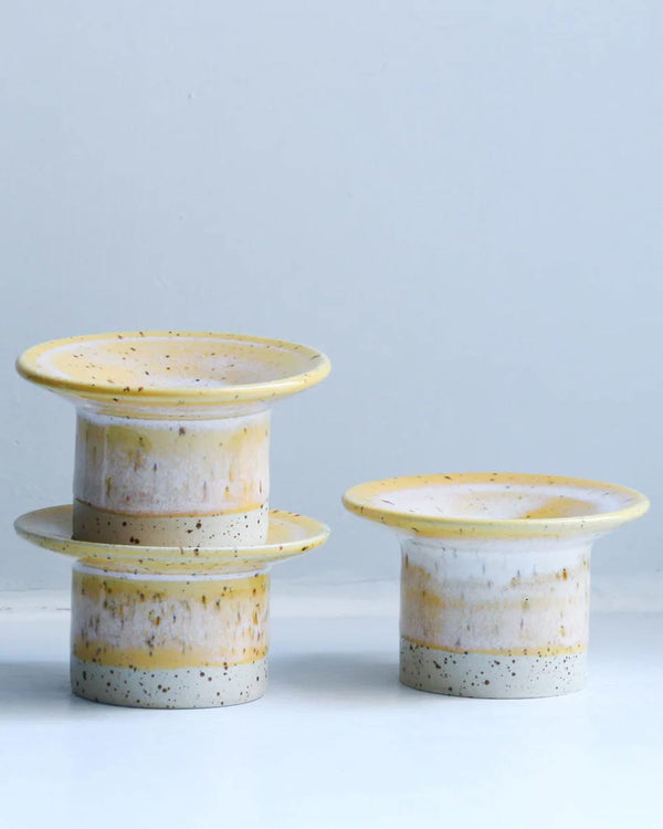 Drei handgefertigte Hono Cornflower Cream Kerzenständer von Studio Arhoj, ideal für Kerzen oder Dekoration, zwei gestapelt, einer einzeln stehend, mit speckigem Ton und sanfter Glasur.