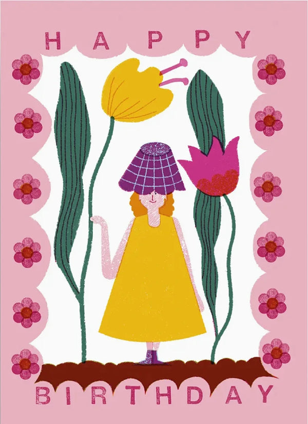 Illustration auf der Birthday Girl Postkarte zeigt eine Figur im gelben Kleid mit lila Hut, umgeben von stilisierten Blumen und einem pinken Rahmen mit HAPPY BIRTHDAY-Schriftzug.