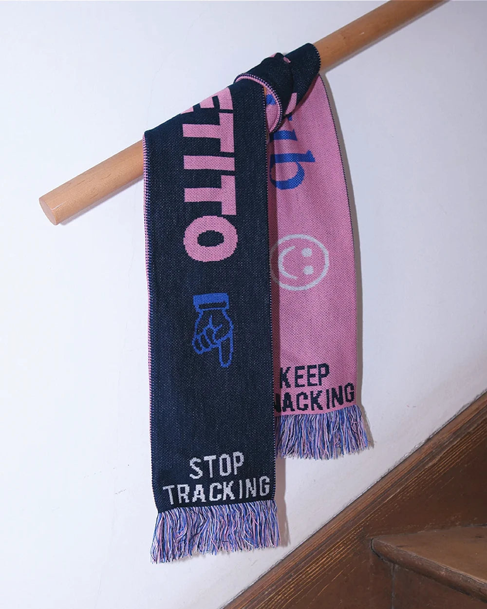 Mangiare Club Schal aus Polyacryl mit zweifarbigem Design: Dunkle Seite mit STOP TRACKING, pinke Seite mit Smiley KEEP TRACKING, bunte Fransen, ca. 145x17cm.