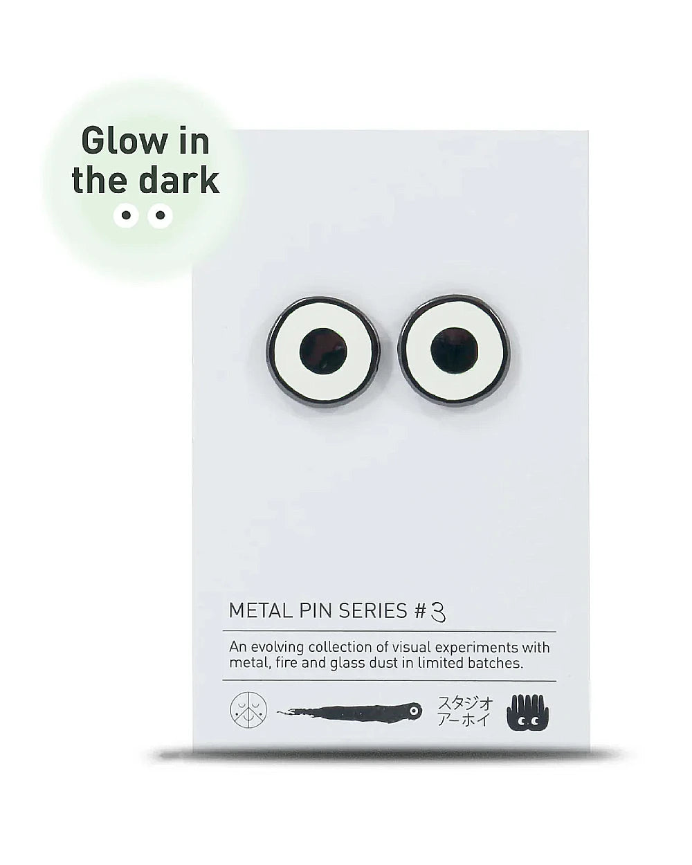 Metal Pin Glow in the Dark Eyes (Serie #3) von Studio Arhoj: Glänzende, runde, leuchtende Metall-Pins mit Silikonrückseite, inspiriert von stilisierten Augen. Maße: 1,5 x 2 cm.