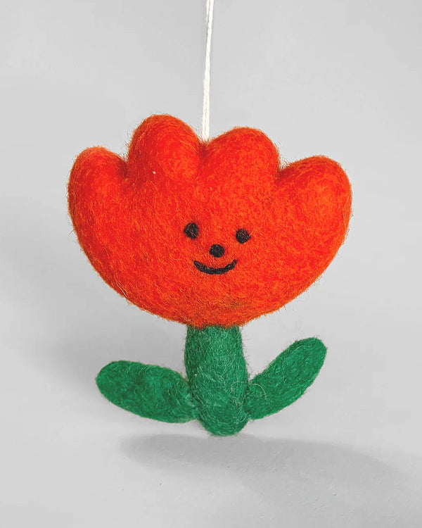 Handgefertigter Flower Filzanhänger mit lächelndem Gesicht, orangefarbenen Blütenblättern und grünem Stiel, aus fair gehandelter Wolle, zum Aufhängen als Dekoration.