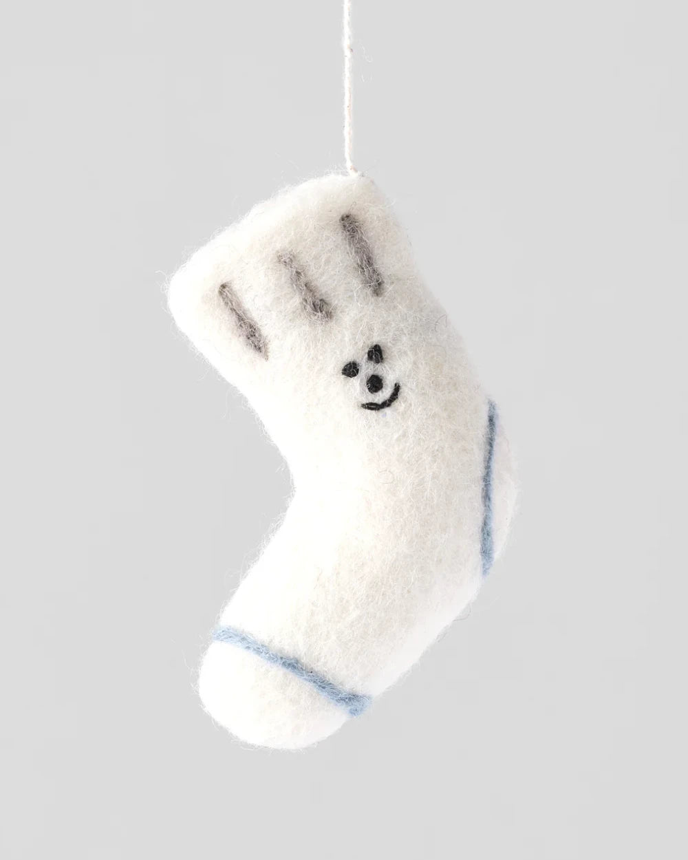 Socke Filzanhänger: Handgefertigter weißer Wollornament mit lächelndem Gesicht, grauen Streifen und blauer Band, aus fairem Handel in Nepal, vom englischen Label Wrap.