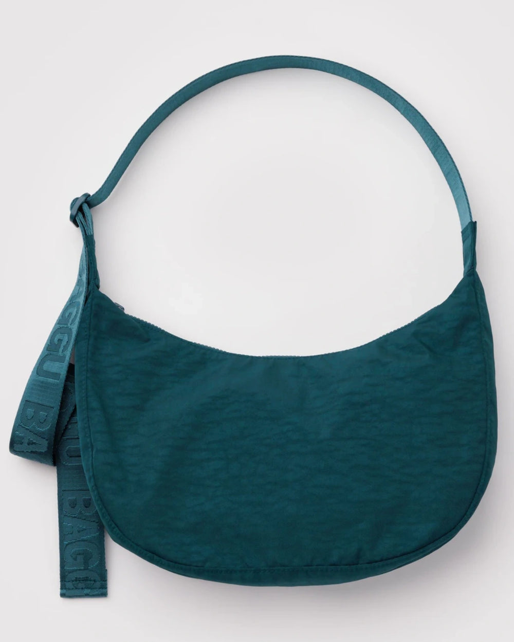 Baggu Medium Nylon Crescent Bag Deep Sea: Halbmondförmige Schultertasche aus teal-nylon, verstellbarer Gurt mit Logo-Detail, enthält Innentaschen und Schlüsselband, ideal für den Alltag.