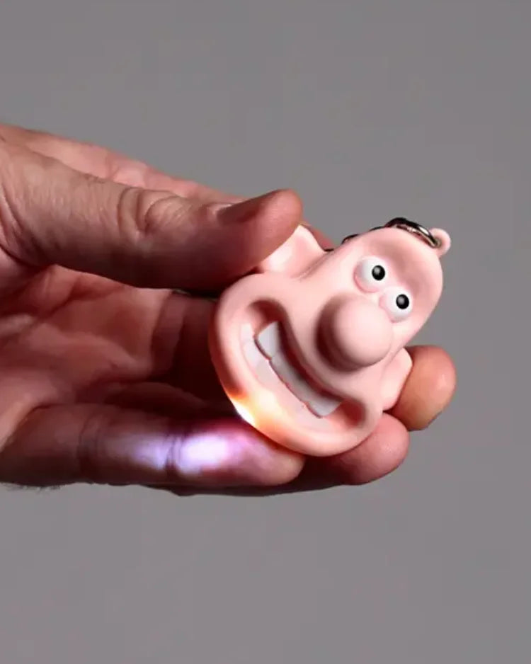 Wallace LED Schlüsselanhänger, ein rosa, cartoonartiger Gesichtskettenanhänger mit LED-Flamme im Mund, aus Kunststoff und Metall, handgehalten, ideal für Sammler.