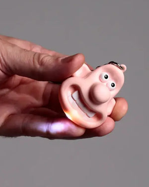 Wallace LED Schlüsselanhänger, ein rosa, cartoonartiger Gesichtskettenanhänger mit LED-Flamme im Mund, aus Kunststoff und Metall, handgehalten, ideal für Sammler.