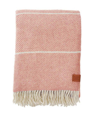 Frank Wolldecke Salmon Pink aus recycelter Gotland-Schafwolle, weich und warm, mit subtilen Streifen und weißen Fransen, ideal für Sofa oder Dekoration.