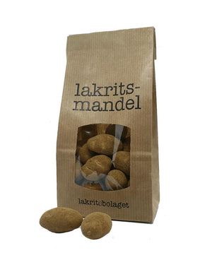 Lakritze Mandel: Braune Papiertüte von lakritsbolaget mit Sichtfenster, zeigt mit weißer Schokolade überzogene Mandeln, gewälzt in Lakritz und Salmiak. Aus Schweden.