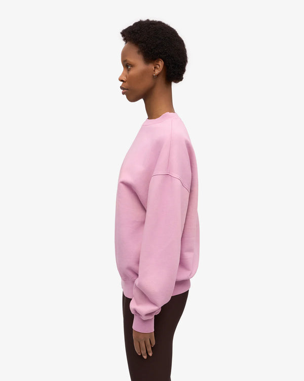 Person trägt das Organic Oversized Sweatshirt Cherry Blossom aus 100% Bio-Baumwolle, kombiniert mit dunkler Hose. Schlichter Stil, ideal für den Alltag.