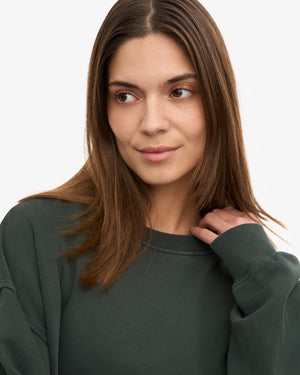 Junge Frau trägt ein Organic Oversized Sweatshirt Midnight Forest aus 100% Bio-Baumwolle, handnah am Hals, präsentiert nachhaltige Mode von Human Empire Shop.