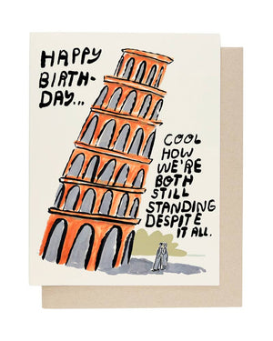 People I've Loved Still Standing Klappkarte mit humorvollem Pisa-Motiv und Spruch über Standhaftigkeit im Alter. Maße: 108 x 140 mm, inklusive Umschlag.