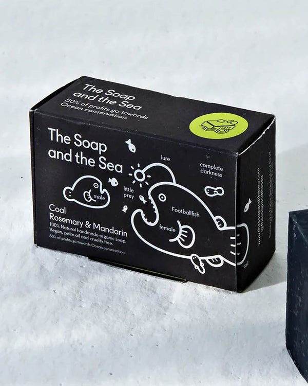 The Soap and The Sea Seife Coal, Rosemary & Mandarin: Schwarze Seifenschachtel, 100% natürlich, vegan, unterstützt Meeresschutz, handgefertigt in Spanien, mit Anglerfisch-Illustration.