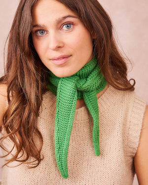 Frau trägt Kleiner Schal aus Wolle Green, ein schmaler, dreieckiger, grüner Strickschal aus Kaschmir-Mix, ideal für Herbst/Winter, hergestellt in Italien. Für alle die farbenfrohe und schöne Accessoires lieben.