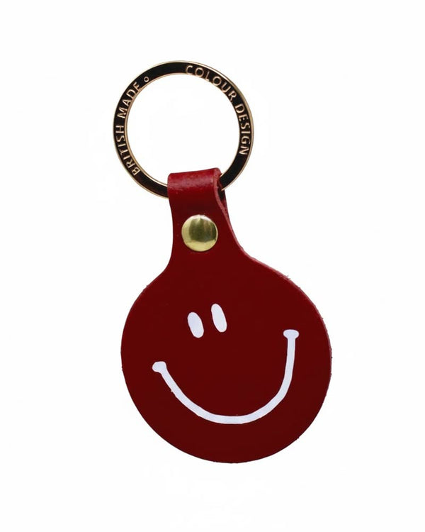 Runder roter Leder-Schlüsselanhänger Feeling Lush Smiley von Ark Colour Design, mit weißem Smiley-Gesicht und vergoldetem Ring, gefertigt in Schottland.