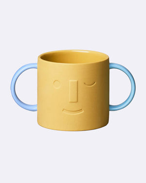Chic.Mic Good Mood Kids Bo: Zweihand-Mustard-Keramiktasse mit stilisiertem Gesicht und blauen Griffen, ideal für Kindergetränke. Spülmaschinen- und mikrowellengeeignet, perfektioniert für kleine Hände.