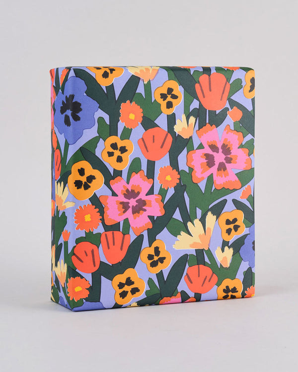 Wrap Wild Flowers Geschenkpapier, gestaltet von Elena Boils, zeigt bunte Blumenmuster auf nachhaltigem Papier. Perfekt für stilvolle Geschenke, erhältlich bei Human Empire Shop.