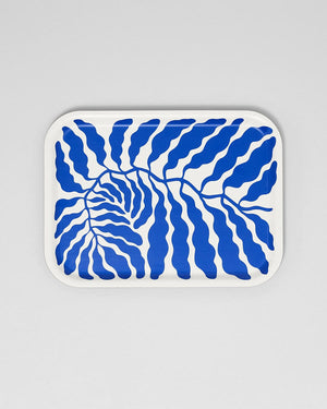Kleines Wrap Blue Leaves Tablett: Weißes Tablett mit abstraktem, wellenförmigem Blattmuster in Kobaltblau, gestaltet von Linnéa Andersson, nachhaltig handgefertigt aus Birkensperrholz in Schweden.
